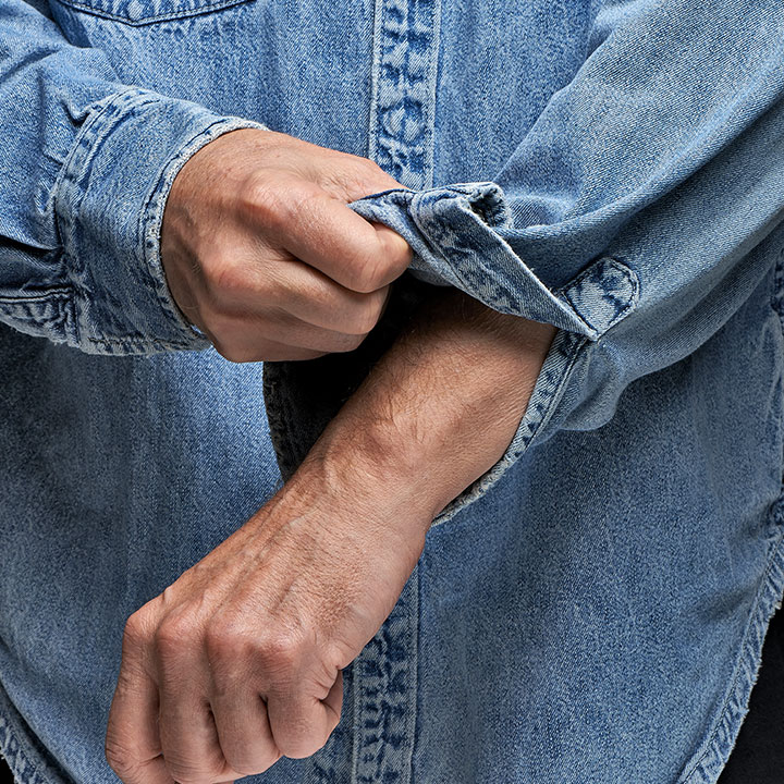 man-in-denim-shirt-rolling-up-his-sleeves-PDMGUZJ